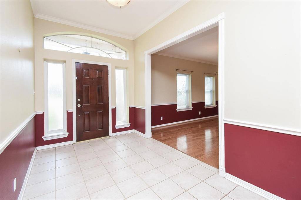 A spacious formal dining area with bold accent walls and gleaming wood floors, ideal for entertaining guests in style.