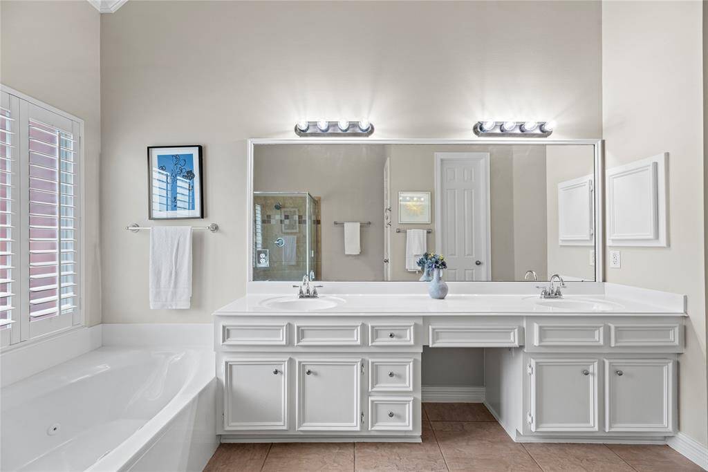 Dual sinks and a built-in makeup vanity turn grooming routines into simple tasks. With no worries over space or storage, both partners will be excited to share this useful and beautiful en suite.