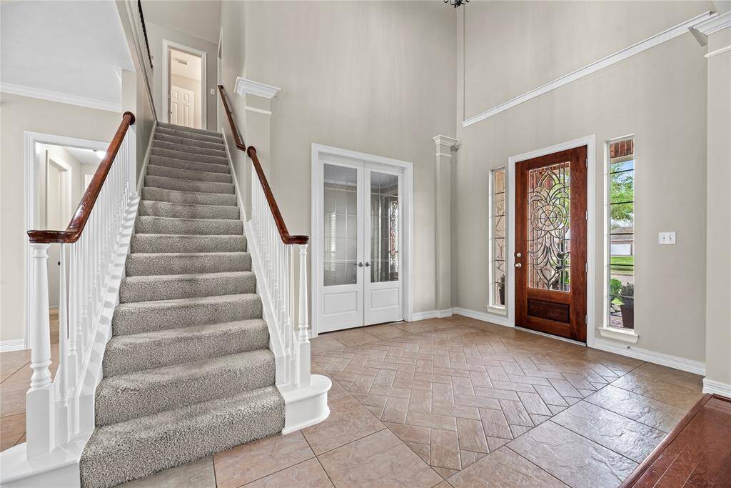 The traditional wooden staircase features bright white spindles, an oak railing, and fully carpeted stairs