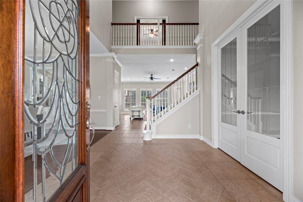 Entering the home, guests are met with durable tile flooring, which is accented with thick white baseboards and an attractive wood front door with sidelights.