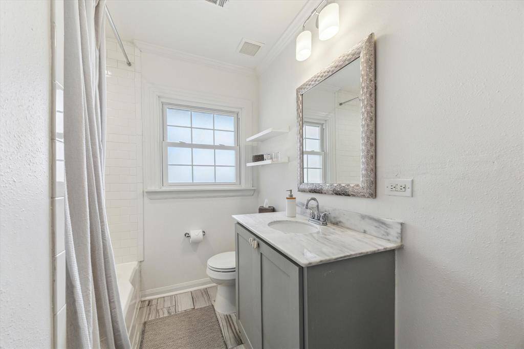 Shared hallway bath with shower/tub combo and marble vanity.
