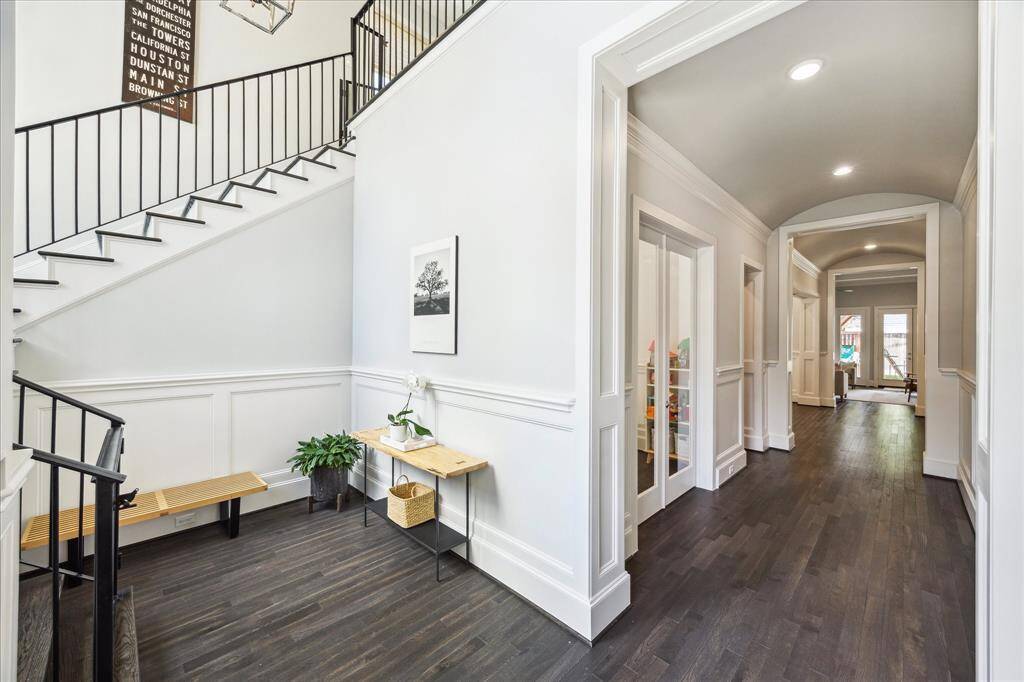 This beautiful entry welcomes you with striking features including high ceilings, architectural stairway and gorgeous wood flooring.