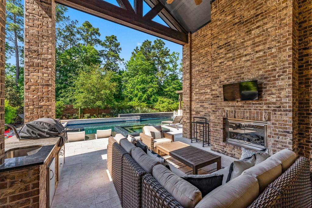 This rear covered porch as an inviting fireplace and culinary center.