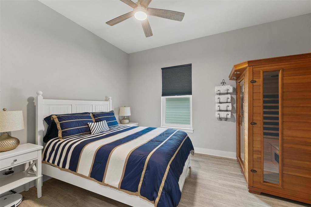 Spacious secondary bedroom features stylish ceiling fan and natural light. Coastal accents add charm and warmth
