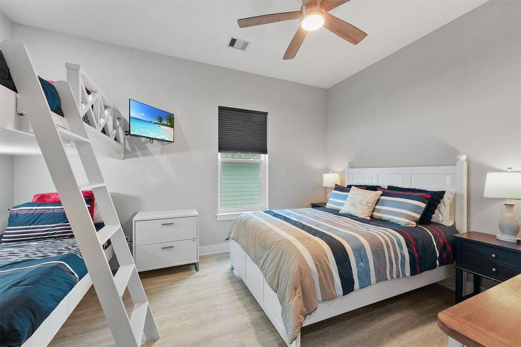 Spacious and fun bunk room setup with full-sized ned and twin bunk above. Perfect for extra guests or kids, with matching coastal bedding and clean finishes