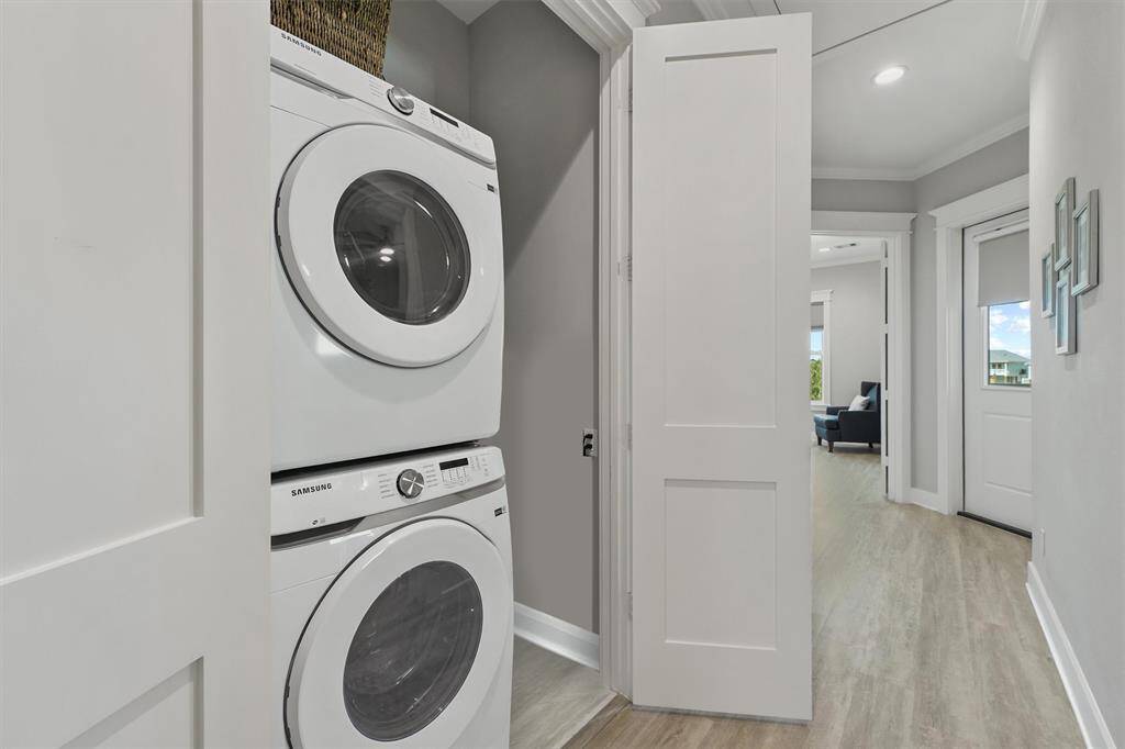 Dedicated laundry space with stacked Samsung washer and dryer, tucked conveniently off the hallway for easy access