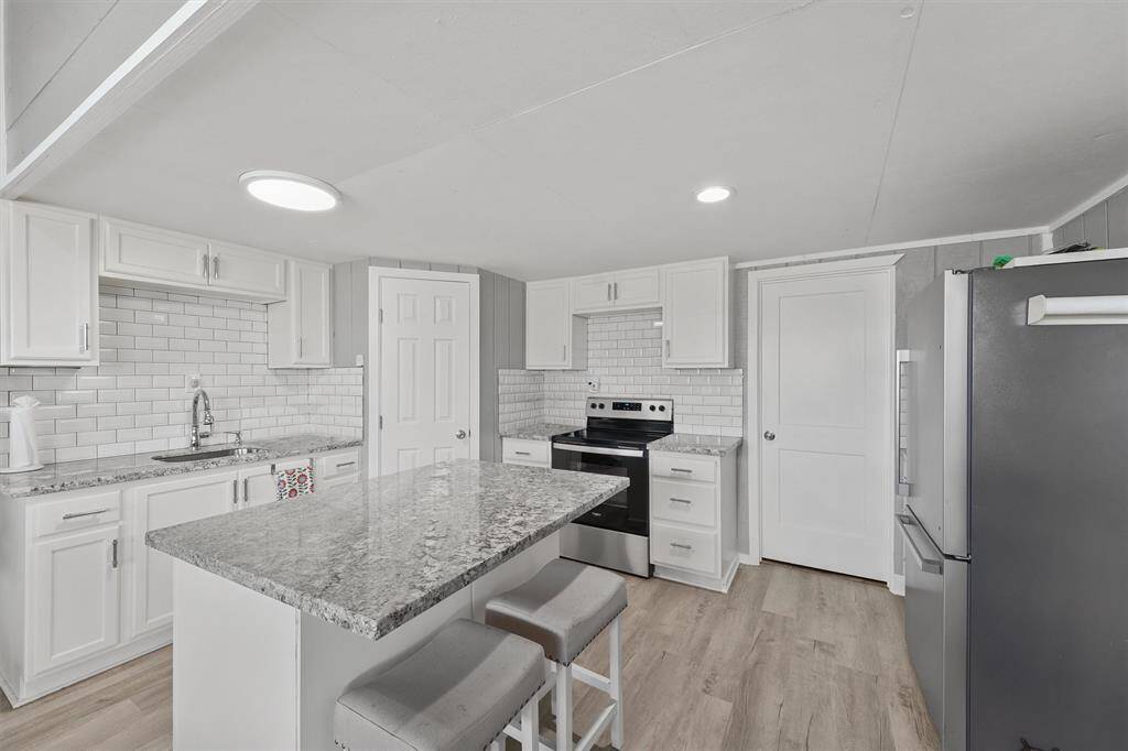 Another view of the downstairs kitchen highlighting the functional layout, stylish finishes, and seamless flow into the adjoining bonus living space