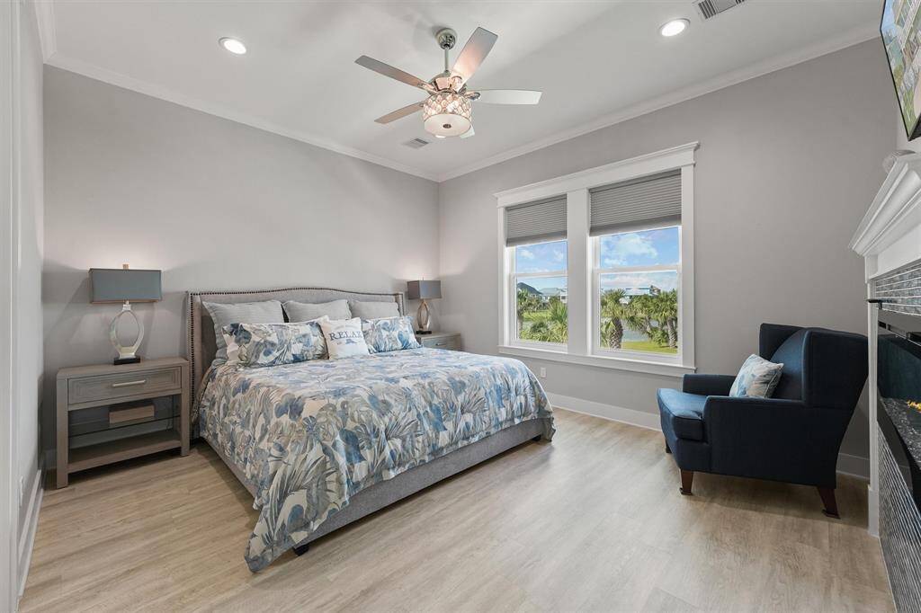 Framed by serene views and soft natural light, the primary suite is a tranquil retreat featuring generous space, luxury vinyl plank flooring, and crown molding.