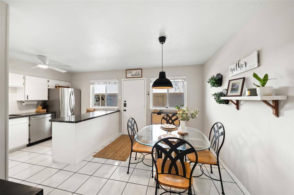 The bright dining area has a welcoming atmosphere with light walls, a pendant light and large recent windows that offer plenty of natural light.