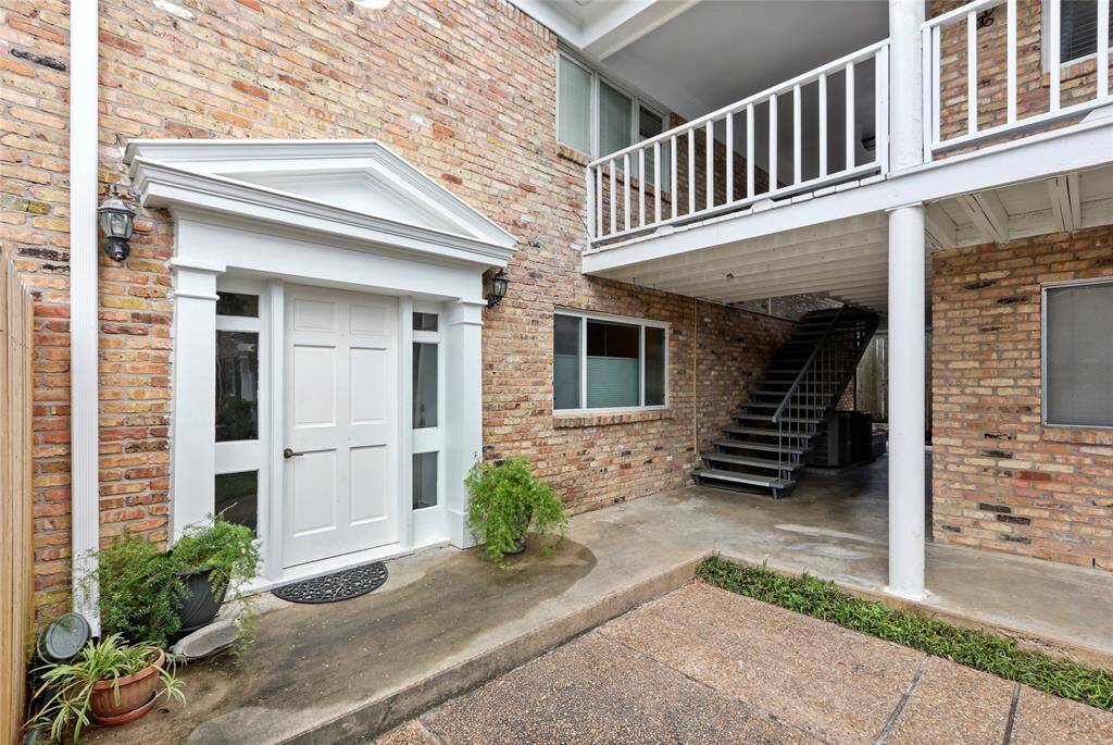 Once you pass the manned privacy gate, you'll head to the back courtyard of the property and enter through this charming exterior entryway with elegant white door set against classic brick.