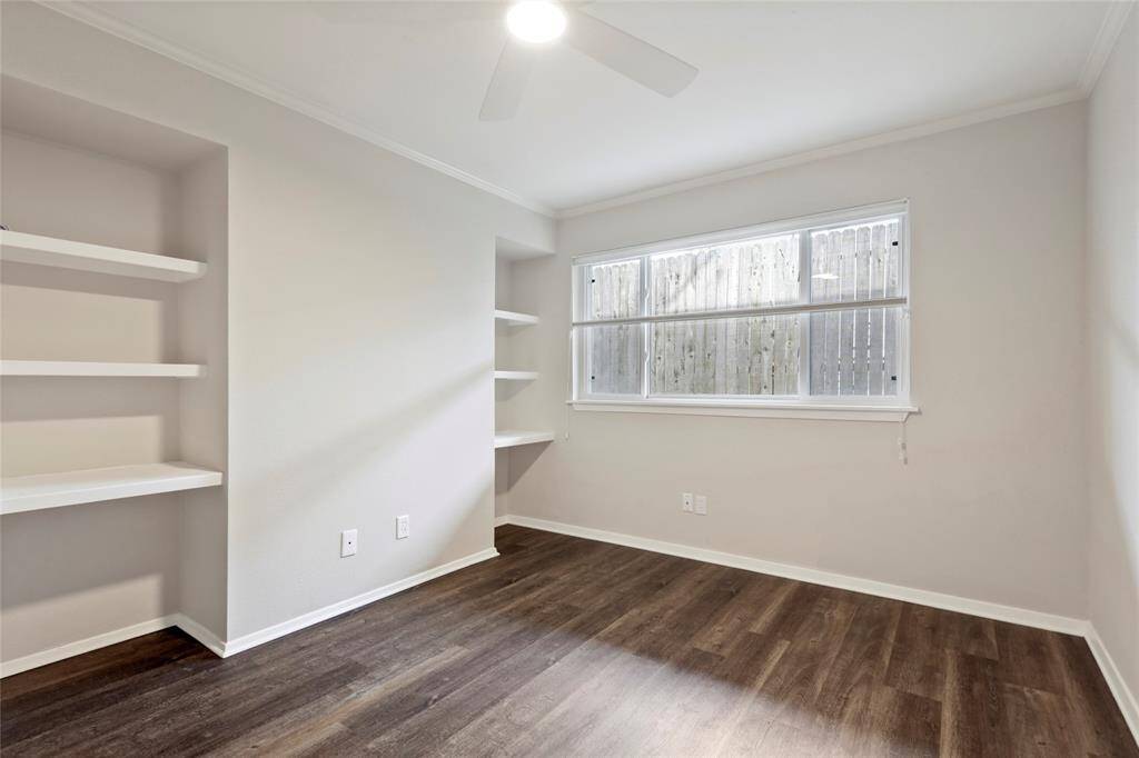 View of desk, shelves/storage in bedroom.