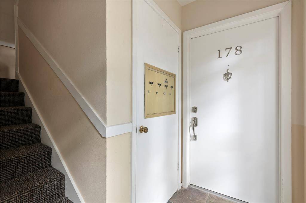 The interior entrance features a sleek door with a modern handle, offering style and security. Private and secure mailboxes right outside your door.