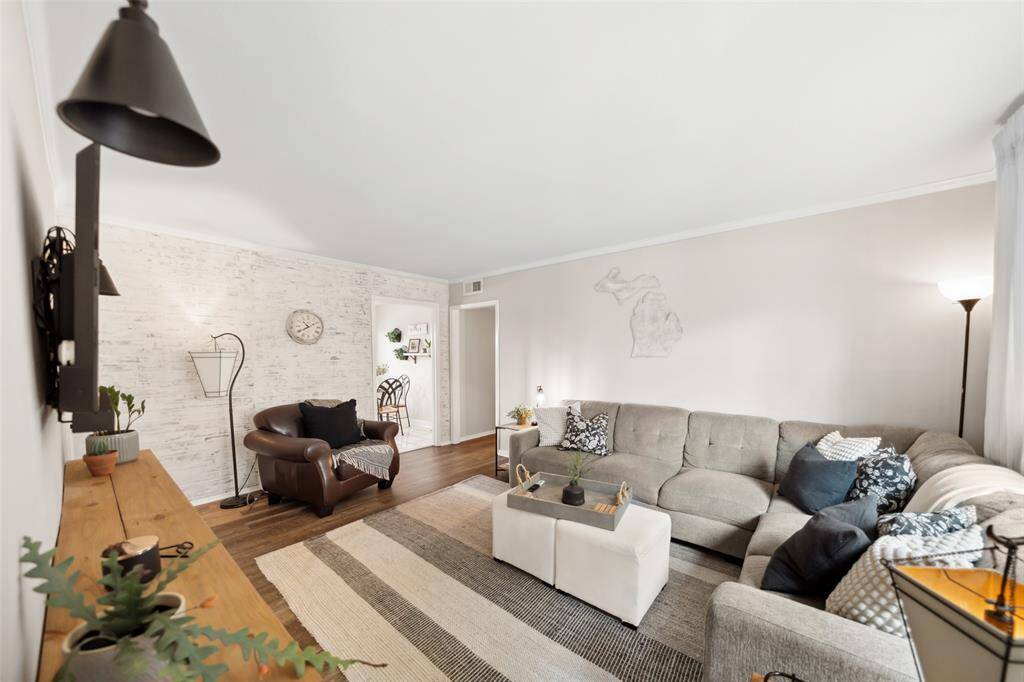 The living room is accented with a brick wall and built-in wooden console.