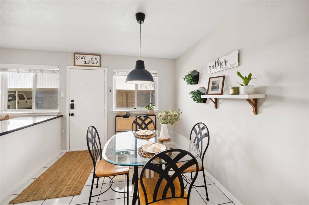 The bright dining area has a welcoming atmosphere with light walls, a pendant light and large recent windows offer plenty of natural light.