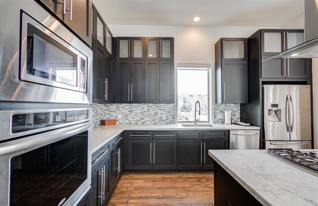 Stainless steal appliances in this stunning kitchen with a window overlooking the city.
