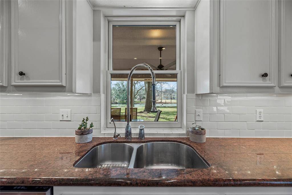 Double stainless-steel sinks make cleaning produce and meal preparation much easier. Check out the amazing view of the back yard.