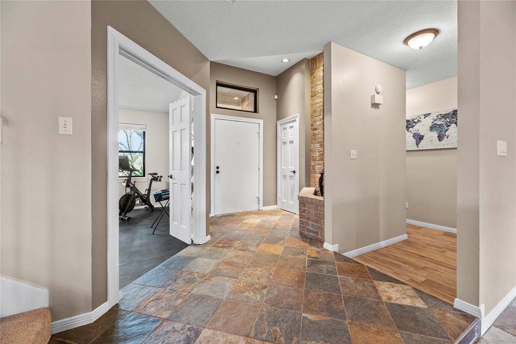 This home showcases a welcoming entryway with a mix of stone tile and wood flooring.