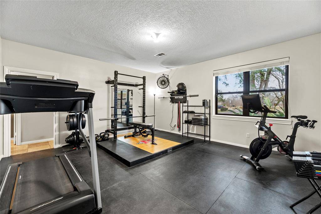 An in-home gym room with rubber flooring provides a durable, cushioned surface that absorbs impact and reduces noise, making workouts safer and more comfortable.