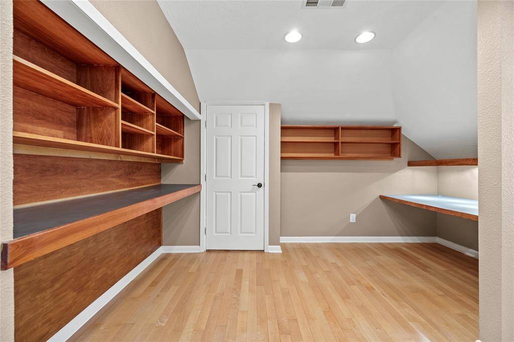 With a built-in desk and ample shelving, this office offers an organized and professional environment for work or study.
