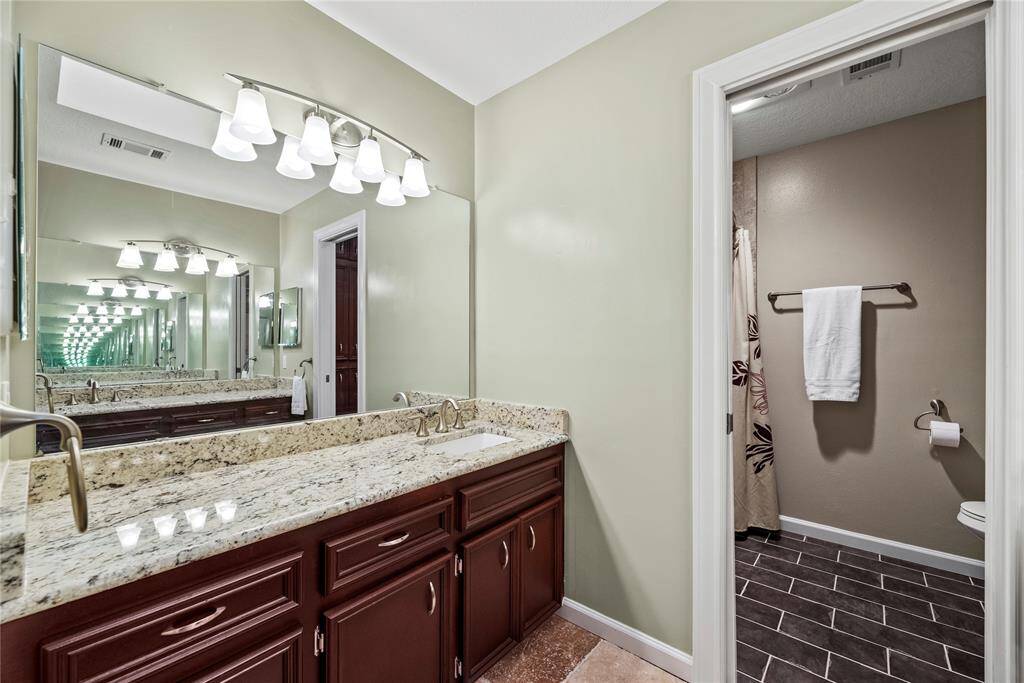 Persistently uniform with stately granite and rich wood cabinetry, the bathrooms are stylish, welcoming, and tidy.