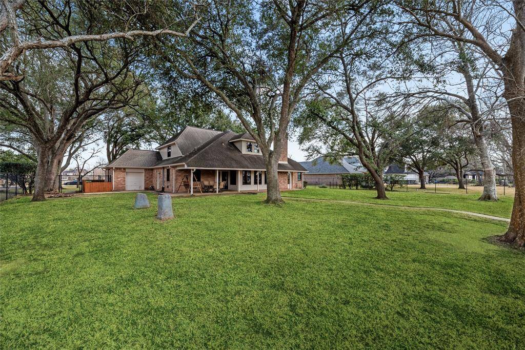 Charming home with a spacious front yard, surrounded by mature trees providing ample shade. The house features a covered back porch and a classic design, ideal for a family seeking a peaceful setting.