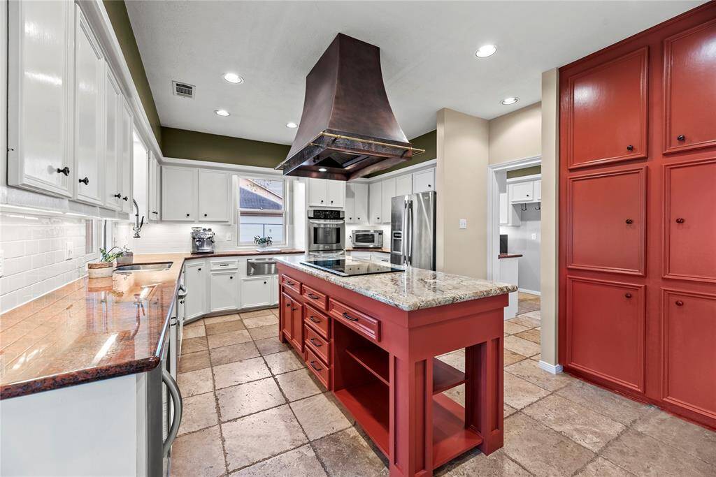 The kitchen features stainless-steel appliances and stunning granite countertops.