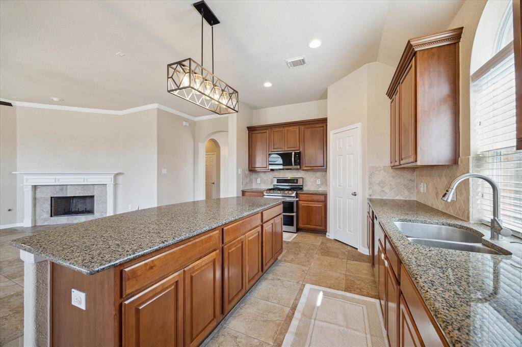 Kitchen has granite countertops tops with stainless steel appliances and upgraded fixture above island!!!