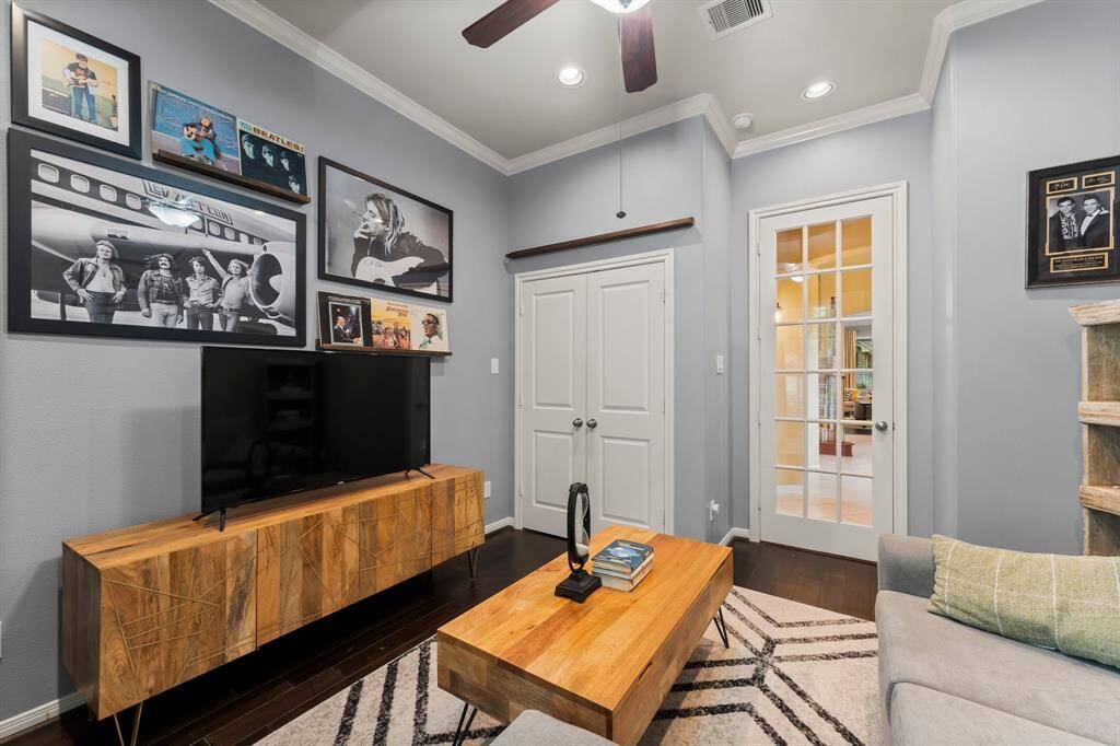 This space is well-lit with a ceiling fan and recessed lighting, and a French door adding character and style.