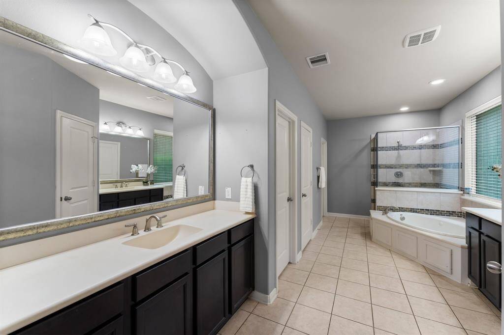 This grand primary bathroom also offers direct access to both the walk-in closet and laundry room, adding everyday convenience to its luxurious design.