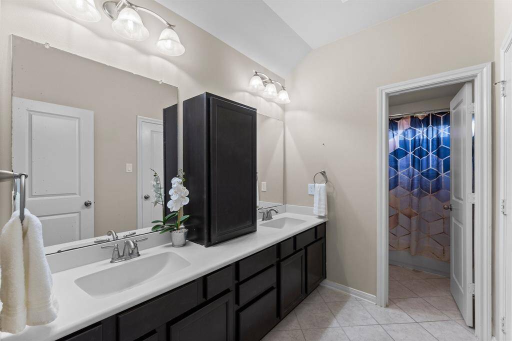 This spacious Jack and Jill bathroom connects two secondary bedrooms featuring dual sinks, a private shower and toilet area, and an abundant amount of light designed for both comfort and privacy.