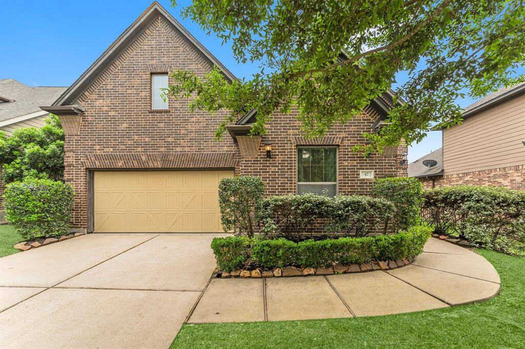 Charming brick home with a steep gable roof. Well-maintained landscaping with lush greenery and a curved pathway create inviting curb appeal.