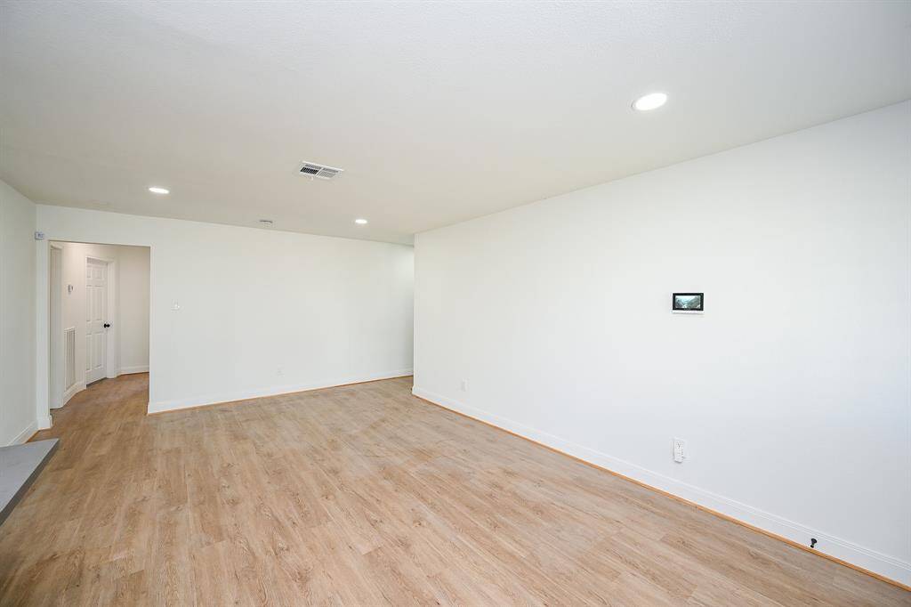 This stunning living room has vinyl plank floors, and recessed lighting.