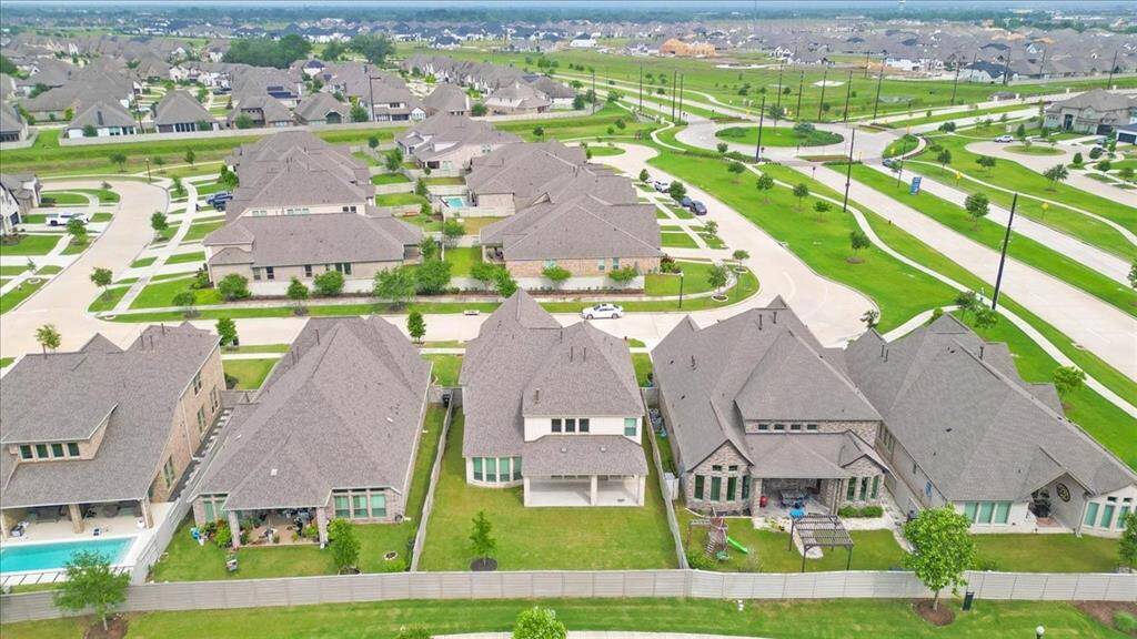 This photo showcases a modern suburban neighborhood with spacious, well-maintained homes, neatly landscaped yards, and wide streets. The area appears peaceful and family-friendly, offering ample green spaces and a pleasant community atmosphere.