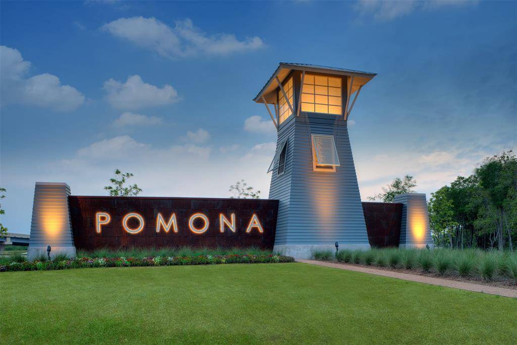 Modern entrance to the Pomona community featuring a well-lit, contemporary tower and landscaped surroundings, creating an inviting atmosphere.