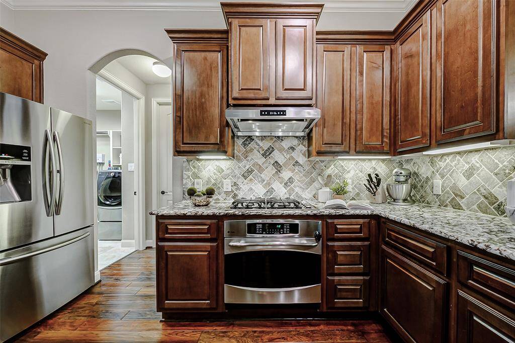 Stainless steel appliances, including an oven and gas cooktop, provide the versatility and precision needed to prepare meals effortlessly, making this kitchen the perfect space for any culinary enthusiast.