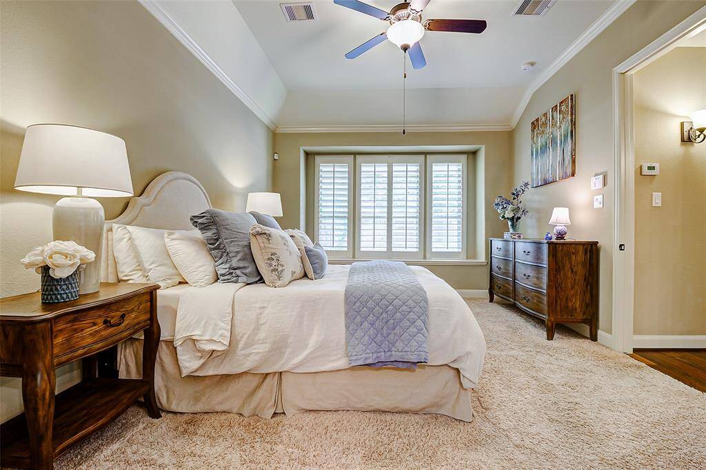 An alternate view of the primary bedroom highlights a large, beautifully framed window, complete with a deep window seat that serves as the perfect reading nook.