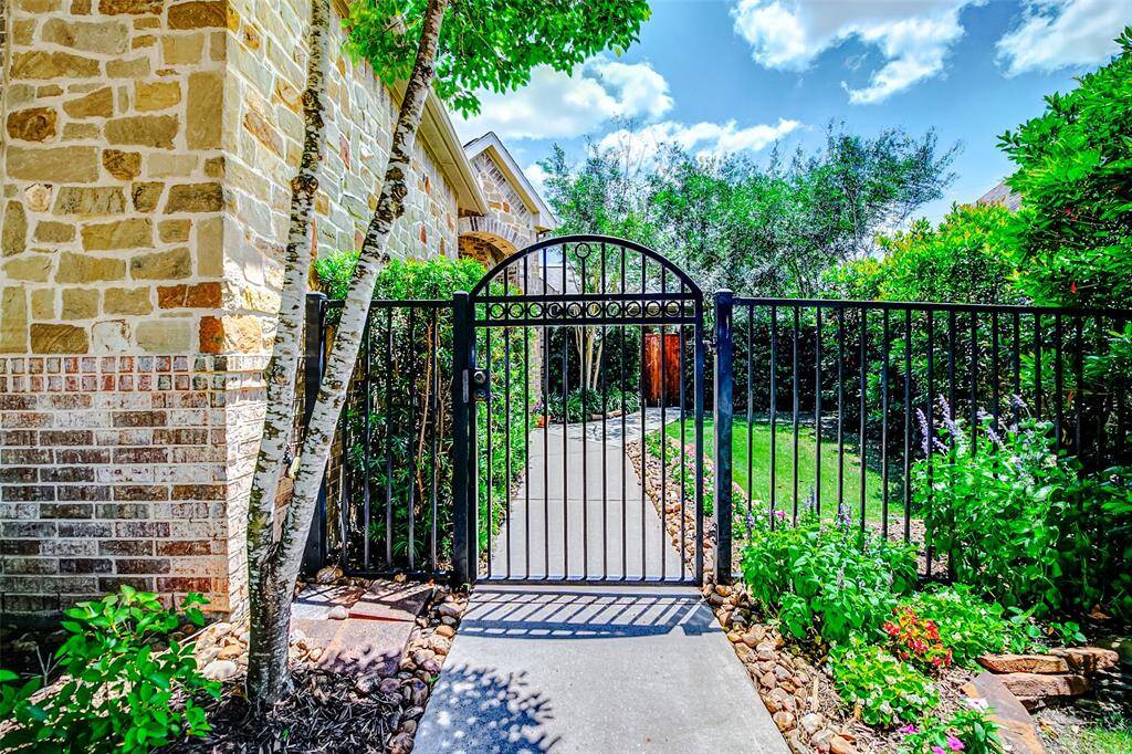 Follow the paved walkway to a private and secure entrance, gracefully set behind a decorative wrought iron fence. This elegant entryway not only enhances curb appeal but also provides an added sense of privacy and safety as you approach the home.