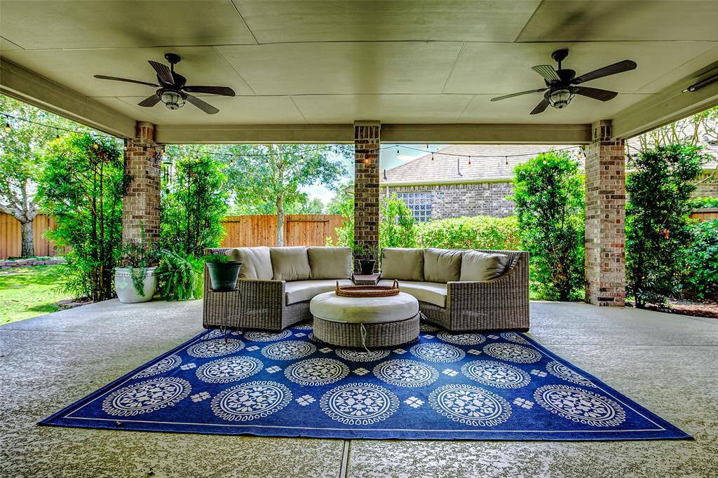 Step out back to the expansive covered patio, offering plenty of room for both outdoor dining and comfortable living area setups—perfect for entertaining or relaxing in style.