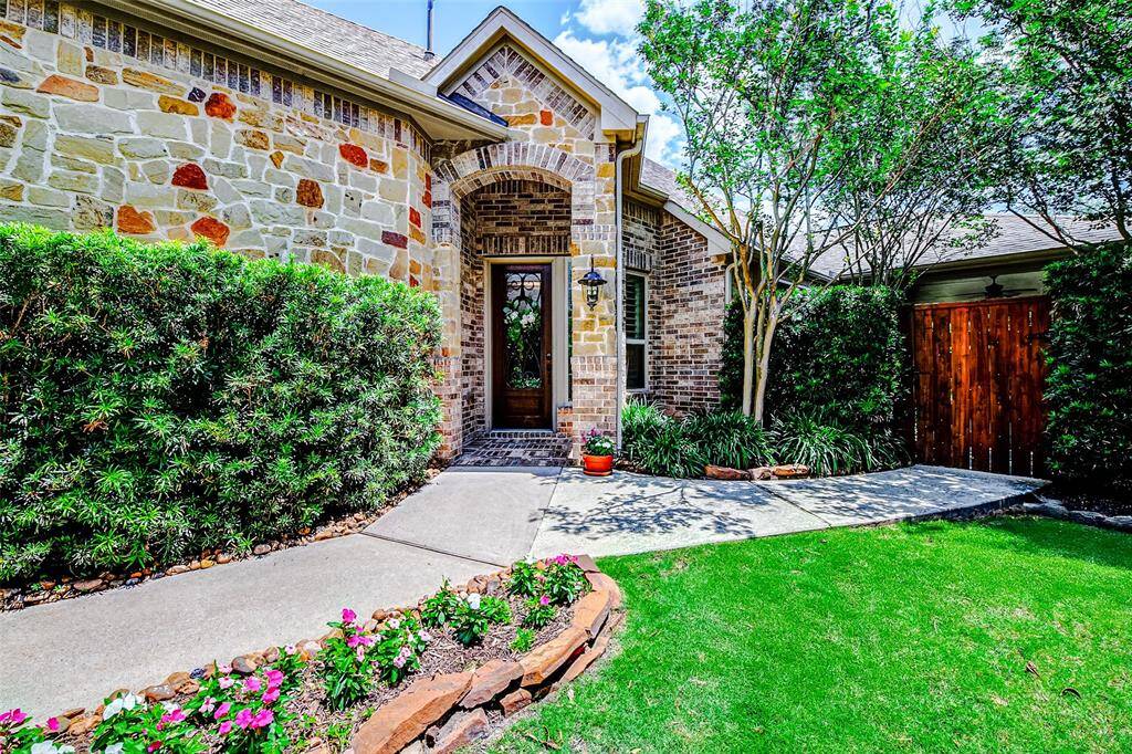 This home showcases exceptional curb appeal with its eye-catching brick and stone exterior, creating a timeless and sophisticated look. Mature trees frame the property, offering natural shade and beauty, while meticulously maintained landscaping and a vibrant green lawn enhance the welcoming atmosphere.