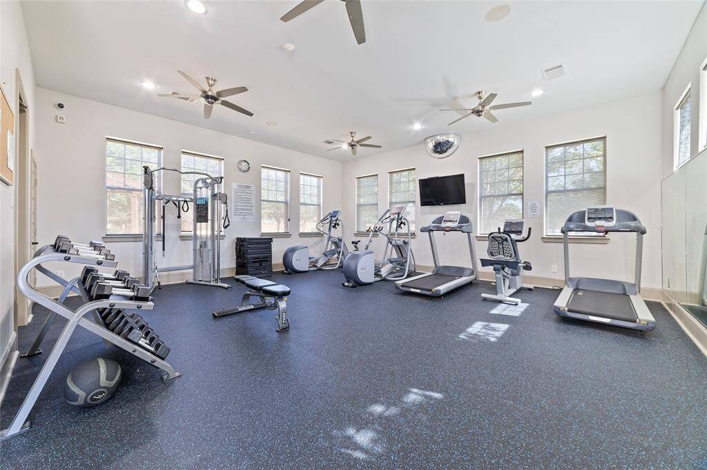 Available to residents, the exclusive clubhouse gym is equipped with treadmills, exercise bikes, weights, strength training machines, and a wall-mounted TV.