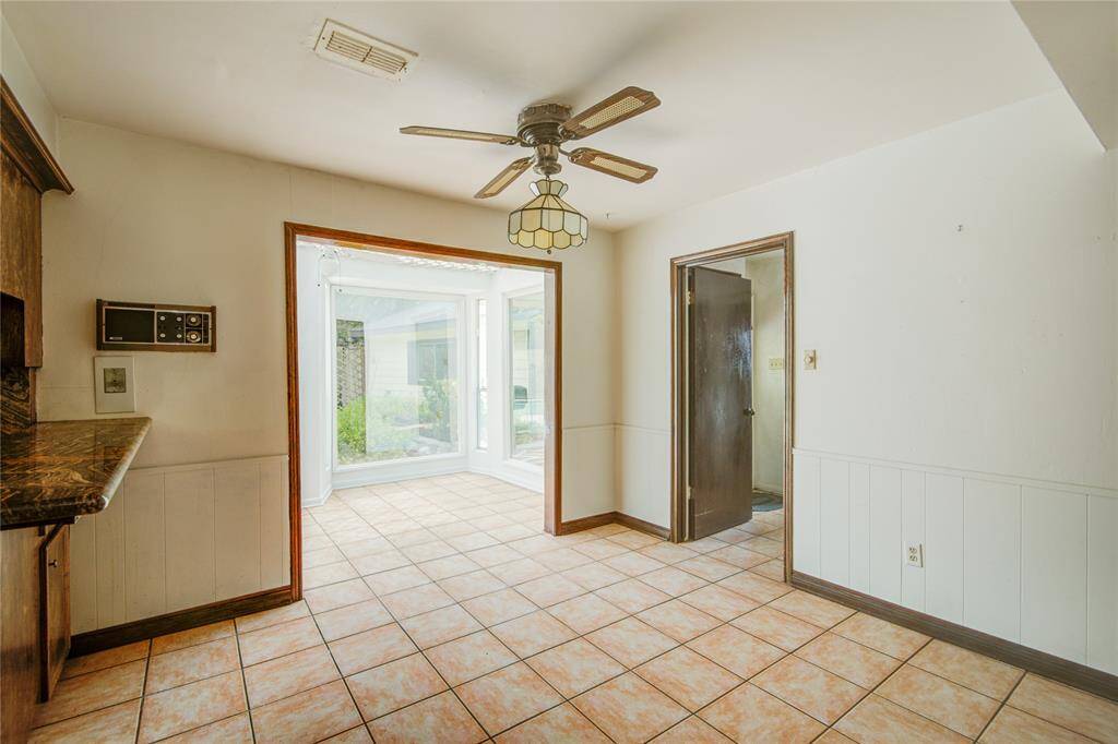 The sunroom as seen from the breakfast area has massive picturewindows for stunning backyardviews.