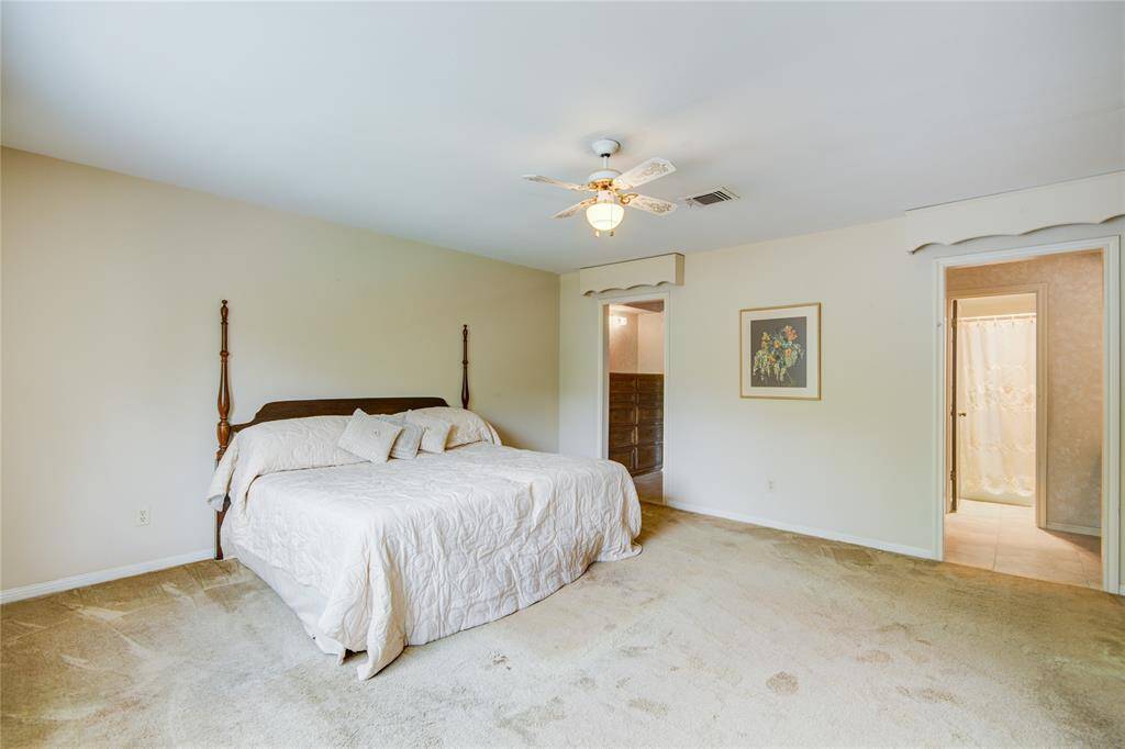 The spacious primary bedroom is filled with natural light and offers an ensuite bathroom and a calming neutral color palette.