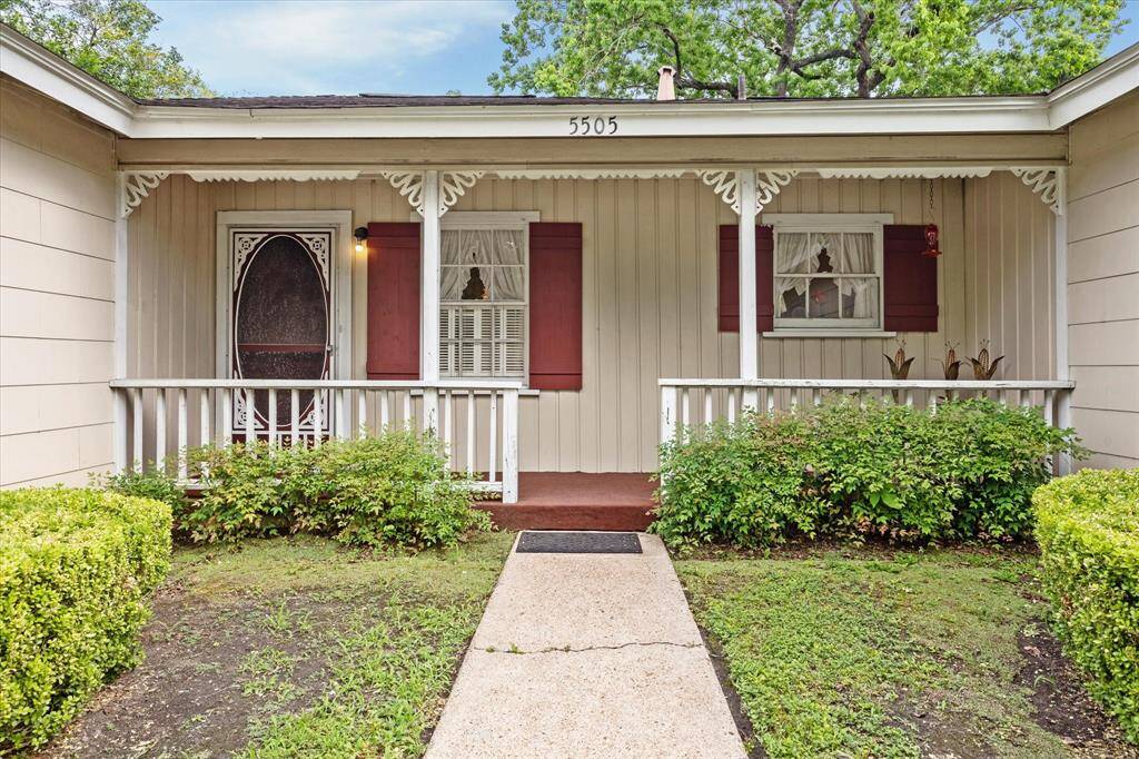 The inviting front entrance features a low-pitched roofline, wide eaves, and a charming covered porch that spans the facade