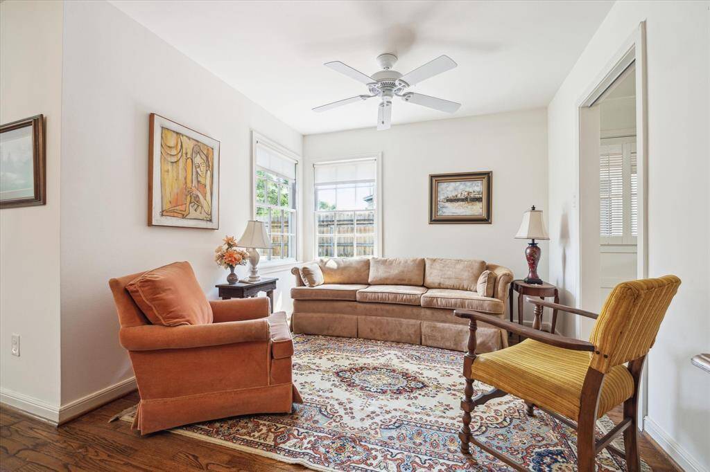 [FAMILY ROOM] This cozy space anchored by original hardwood floors and large windows that pour in natural light,  is perfect for relaxing evenings or lively gatherings.