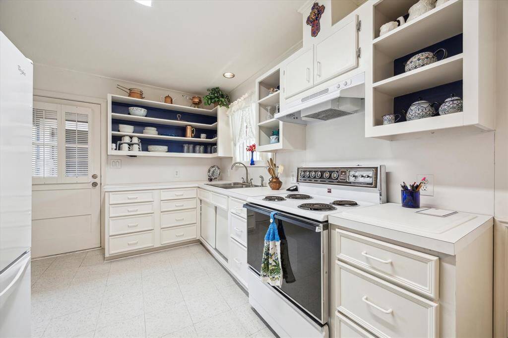 [KITCHEN] This adorable kitchen is full of charm and light, featuring crisp white cabinetry that adds a fresh, airy feel to the heart of the home. Classic in design yet functional in layout, it offers ample storage, gleaming countertops, and vintage-inspired hardware that nods to the home's original characte