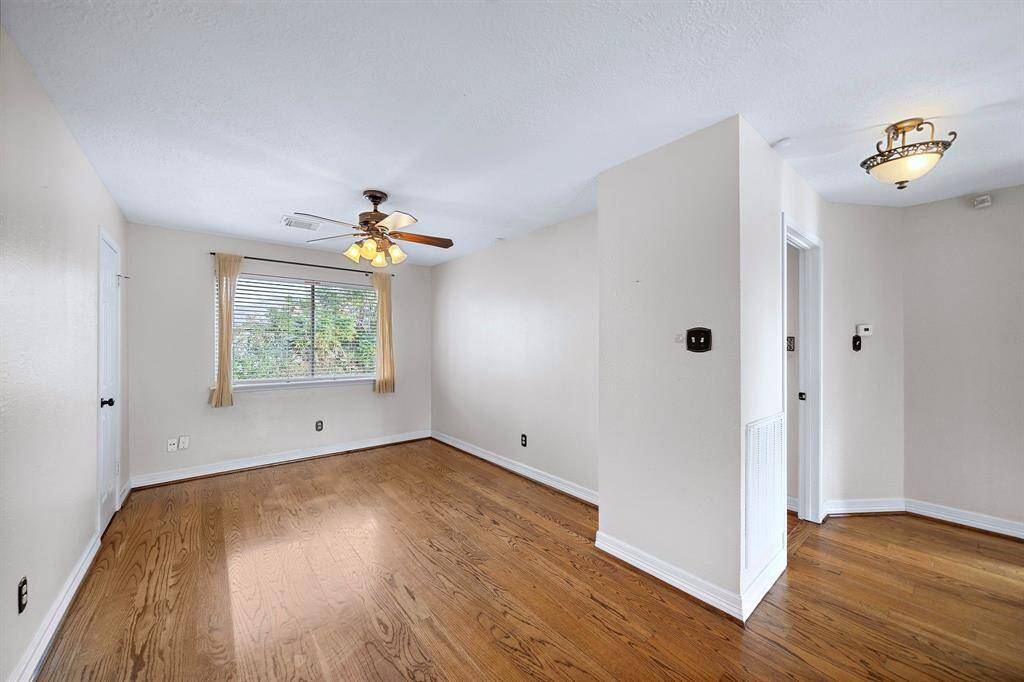Versatile flex space with hardwood floors and a walk-in closet, perfect for a game room, home office, additional living area, or office.