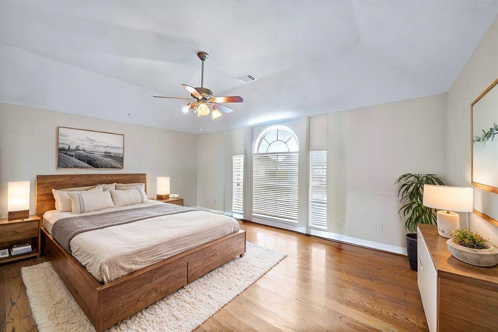 *Virtually Staged*The expansive primary bedroom offers tall ceilings, hardwood floors, arched windows, and not 1 but 3 closets!