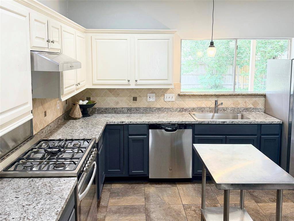 Large windows fill the space with natural light, complementing the ample cabinetry and open design.