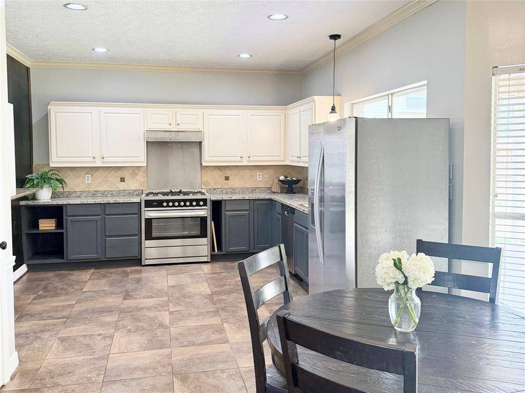 The bright and airy kitchen flows seamlessly into the breakfast nook with charming bay windows, offering open sight lines to the living room and all main downstairs areas.
