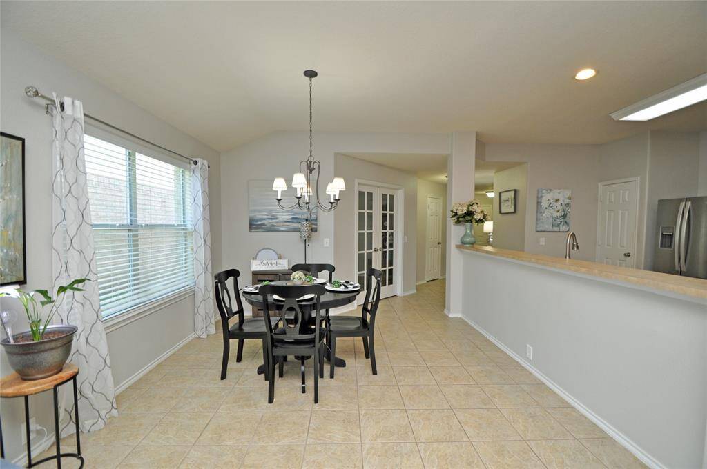 This view shows the open kitchen area, home office and a long bar that is perfect for extra seating.